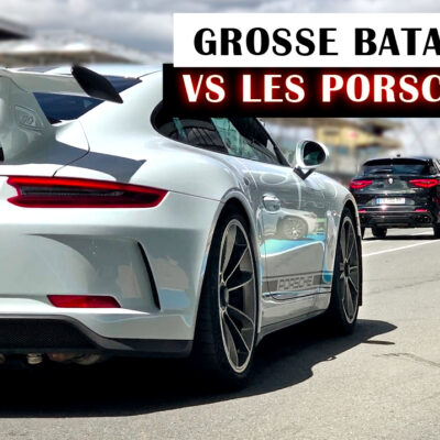 Un SUV qui se bataille sur circuit avec des Porsche